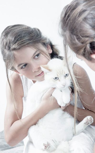 Melissa Doblado segura gato em frente ao espelho