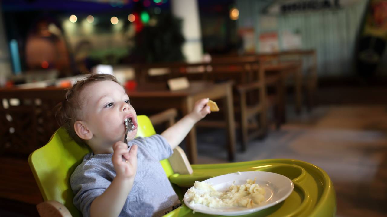 Criança no cadeirão comendo almoço