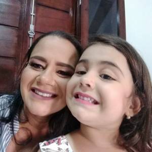 Mãe e filha sorrindo ao tirarem uma foto juntas