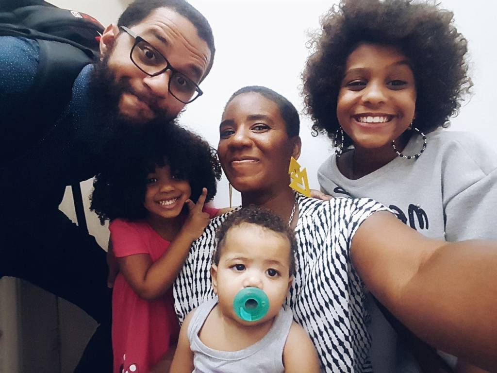 Carla Cavallieri no centro, a filha Ágatha à direita, Akillah com a chupeta, o marido Samuel e Aisha de rosa.