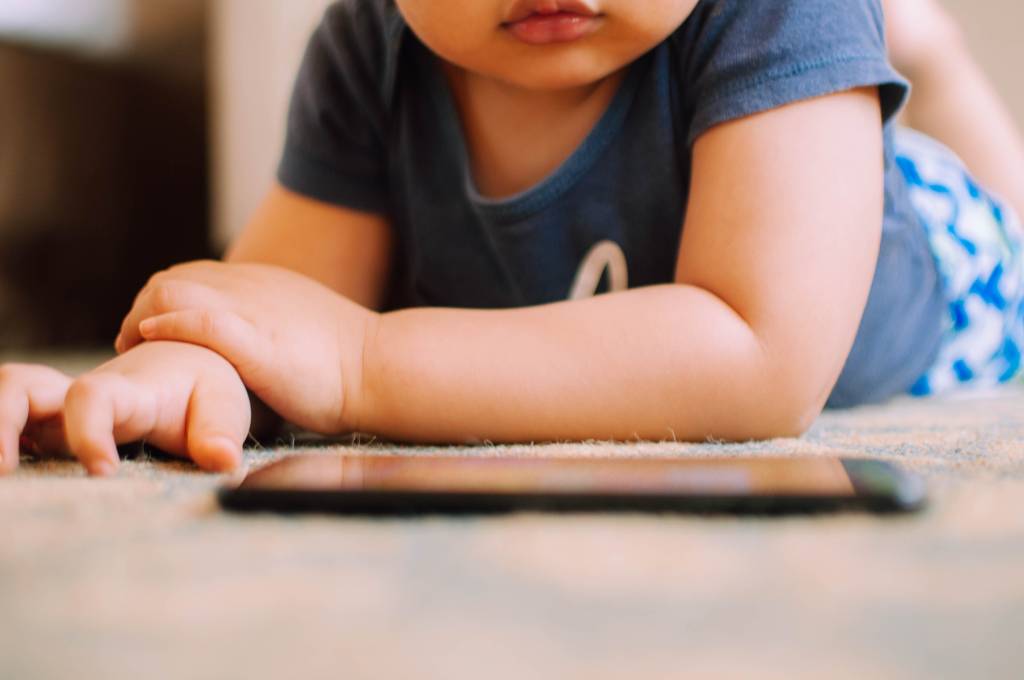 Bebê está olhando o celular assistindo vídeos