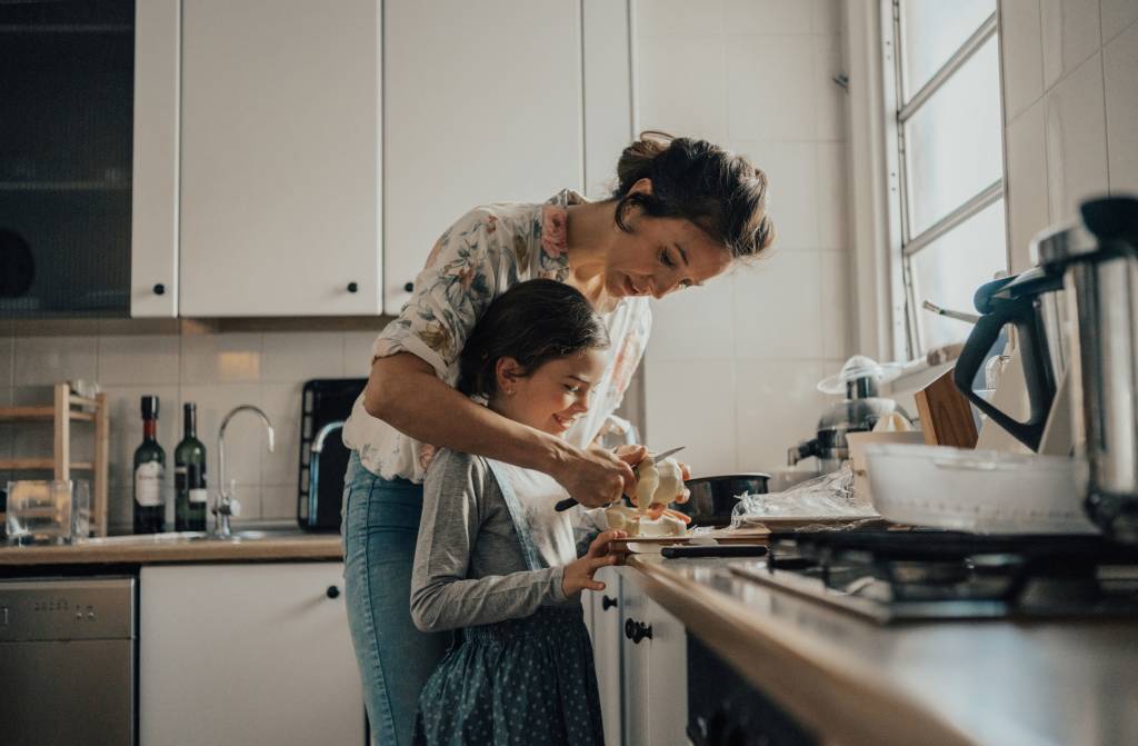 Mãe e filha cozinhando juntas