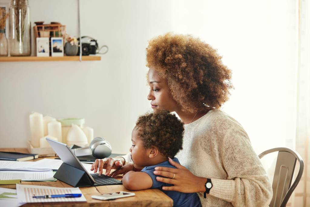 Mãe trabalhando com filho no colo