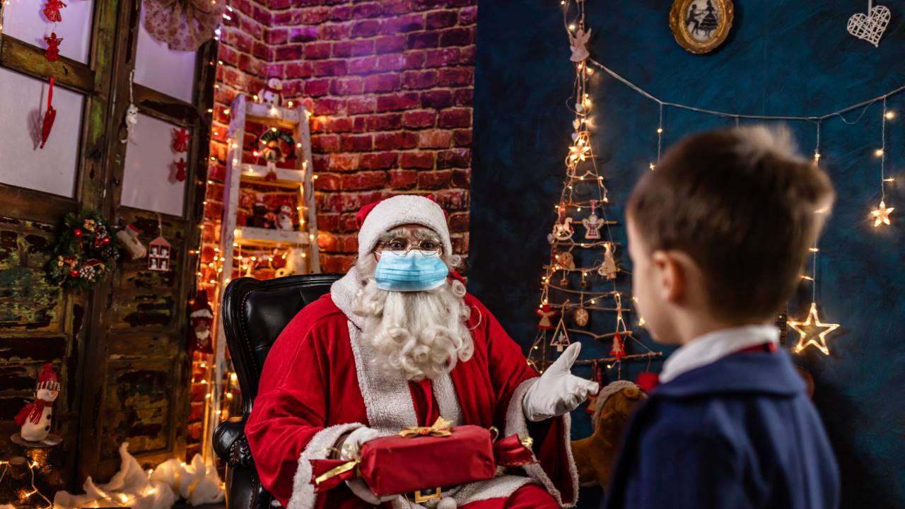 Papai-Noel-de-mascara-e-distanciamento-conversando-com-uma-crianca