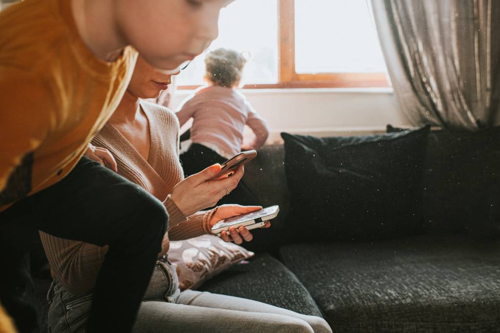 Crianças-correndo-no-entorno-da-mãe-que-segura-o-celular