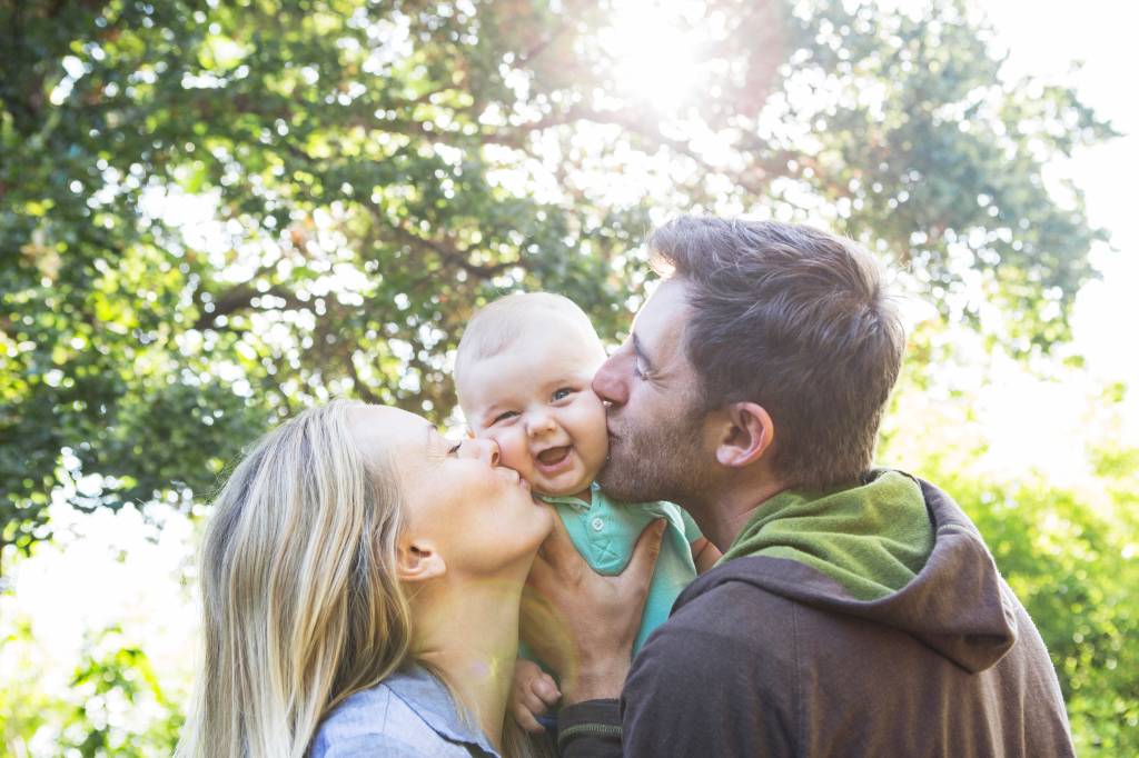 Pais com bebê família beijo