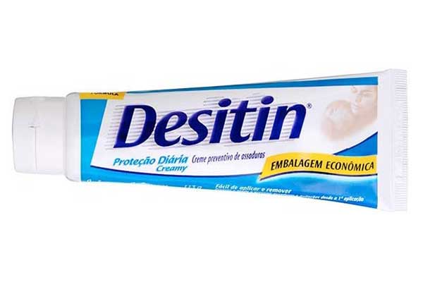 Creme-Preventivo-de-Assaduras-Desitin embalagem plástica triangular em forma de bisnaga, posicionada com a tampa para o lado, deitado