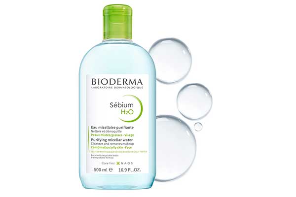 Sébium-H2O-água-micelar-antioleosidade-Bioderma garrafa plástica transparente com um líquido também transparente dentro. Atrás dela, há algumas bolhas de água