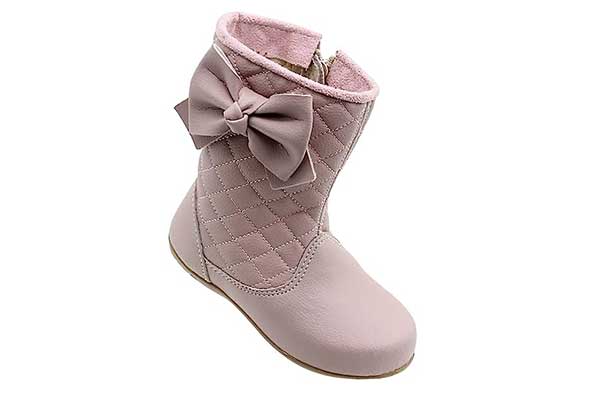 um pé de uma bota cor de rosa infantil de cano médio com um laço no cano