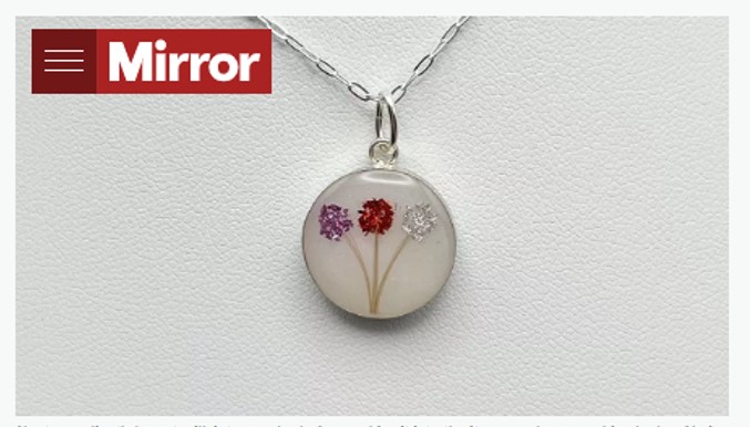 foto pingente de leite materno Pingente feito de leite materno. Tem formato redondo e três florzinhas.
