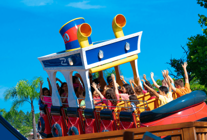 Atração do parque Hopi Hari. Tem formato de submarino, as pessoas estão sentadas nele com os braços para cima. O céu de fundo é bem azul.